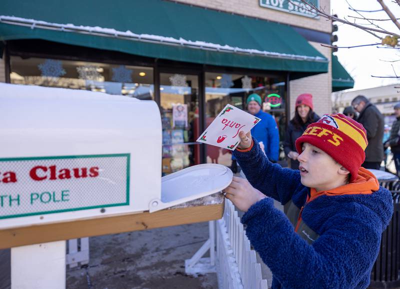 Patrick O’Malley, 9, of Downers Grove places a letter for Santa Claus in a mailbox outside of the Gingerbread House in Downers Grove, Ill. on Sunday, Dec. 18, 2022.