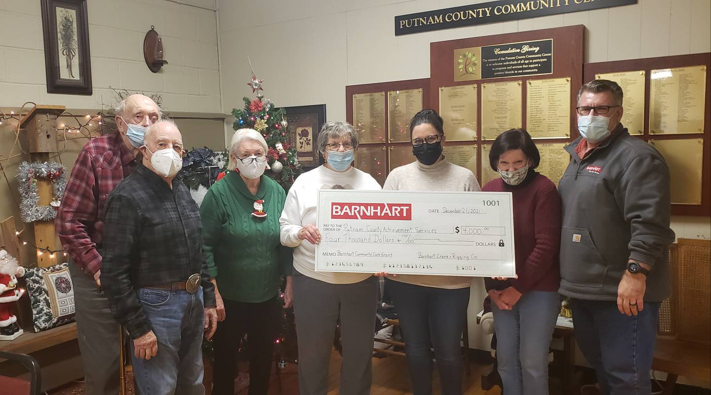 Barnhart Crane and Rigging Co. in Ladd employee Rob Struthers presents Putnam County Achievement Services with its second Barnhart Community Care Grant of $4,000.