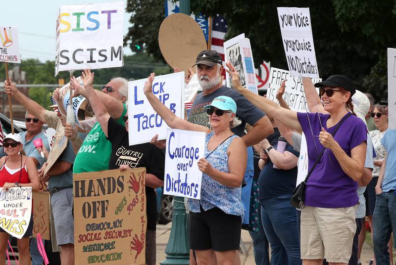 Protesters wave as cars honk in support Saturday, July 4, 2025, at the corner of Main and State Streets in front of the DeKalb County Courthouse in Sycamore during a "No Kings" rally to voice their displeasure with President Donald Trump.