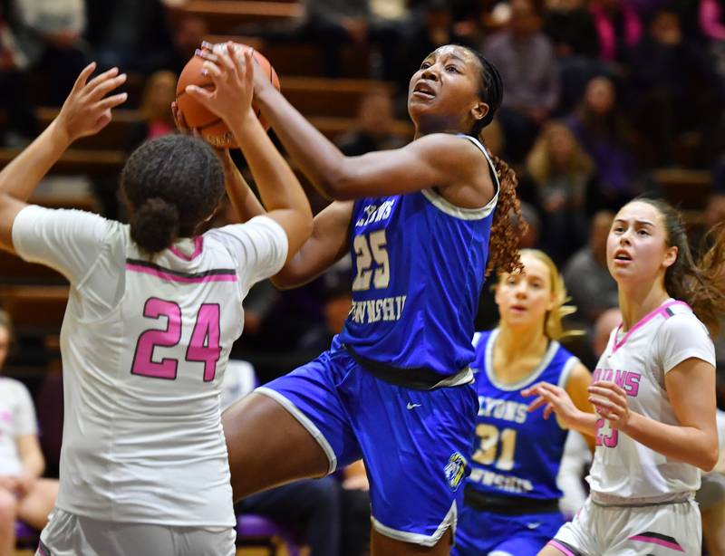 Lyons Township's Nora Ezike (25) takes the ball to the basket during a game against Downers Grove North in January 2024 at Downers Grove North High School in Downers Grove .