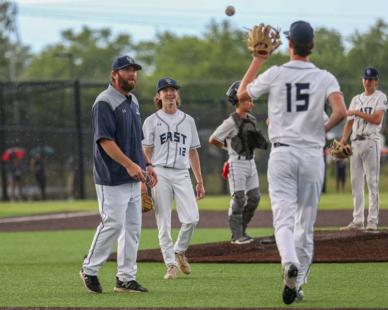 Oswego East's Ryan Johnson (15) comes in to relieve  Patrick Flynn (12) during Class 4A Romeoville Sectional semifinal between Oswego East at Downers Grove North.  May 31, 2023.
