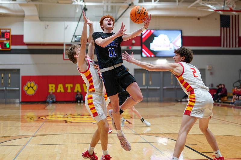 Burlington Central's Patrick Shell (11) drives to the basket against Batavia’s Ben Silbernagel (12) and Darian Susic (2) during a Batavia Night of Hoops Basketball game at Batavia High School on Saturday, Jan. 25, 2025.