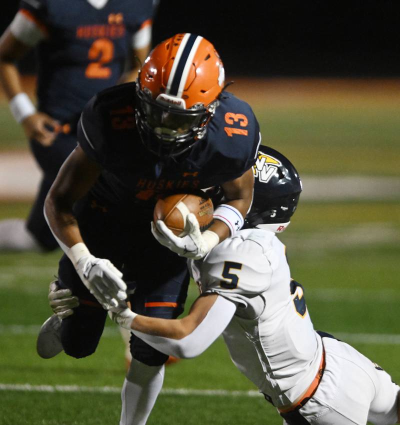 Naperville North’s Rahsean Blake-Eiland, left, gets tackled by Neuqua Valley’s Nick Pape during a football game played on Friday, Oct. 11, 2024 in Naperville.