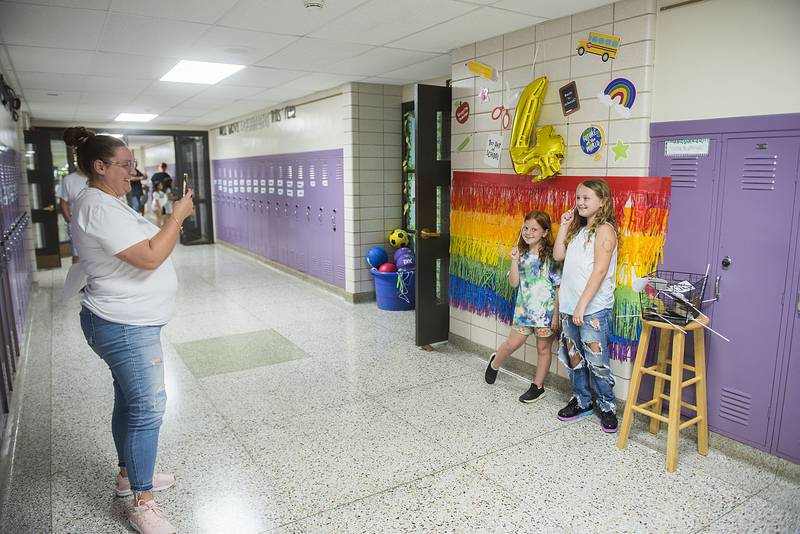 Alicia Oleson snaps a picture of her two daughters Delilah (left), 7 and Laynie, 9 during a welcoming of students and parents to Madison School in Dixon on Monday.