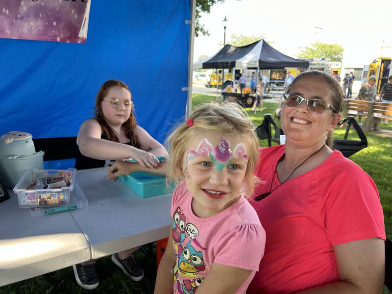 Leeah LeFevre, 5, and her aunt, Robin Keene, received temporary tattoos by Juniper Mentuis at the Painted Panda Designs booth at the National Night Out event in Mt. Morris on Tuesday, Aug. 5, 2025. The event also included displays and booths by the fire dpartment, Mt. Morris Village, and other agencies.