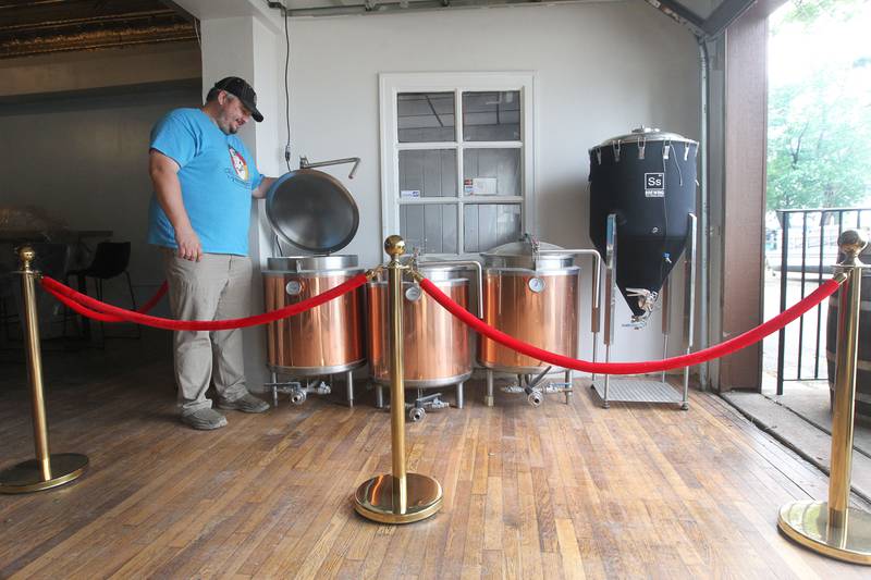 Joshua Grubbs, president/brewer, looks at one of the boil kettles he will be using for brewing at the Black Lung Brewing Company’s new location under construction in Fox Lake on Monday, June 26, 2023. The small brewery from Round Lake Beach has started a Kickstarter fundraiser called, Black Lung Expansion to Fox Lake and features a prize called, "Name the Fermenter or a Kettle". The grand opening for Black Lung Brewery Fox Lake, at 115 Nippersink Rd., is on July 22nd from 3-5pm. 
Image by Candace H. Johnson for Shaw Local News Network