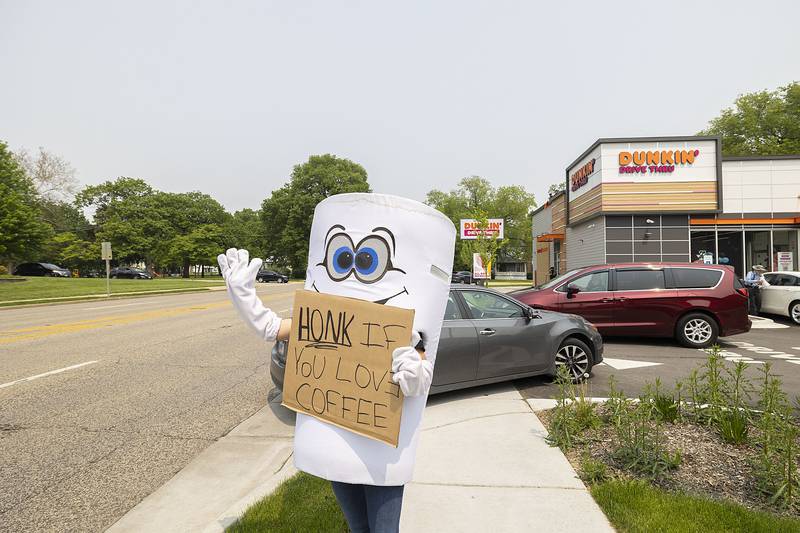 The spokes-coffee for Dixon’s Dunkin’ Donuts waves to traffic Friday, May 19, 2023 as part of the Illinois Law Enforcement Special Olympics fundraiser. Officers across Illinois took to their local Dunkin’ Donuts to raise money for the organization.