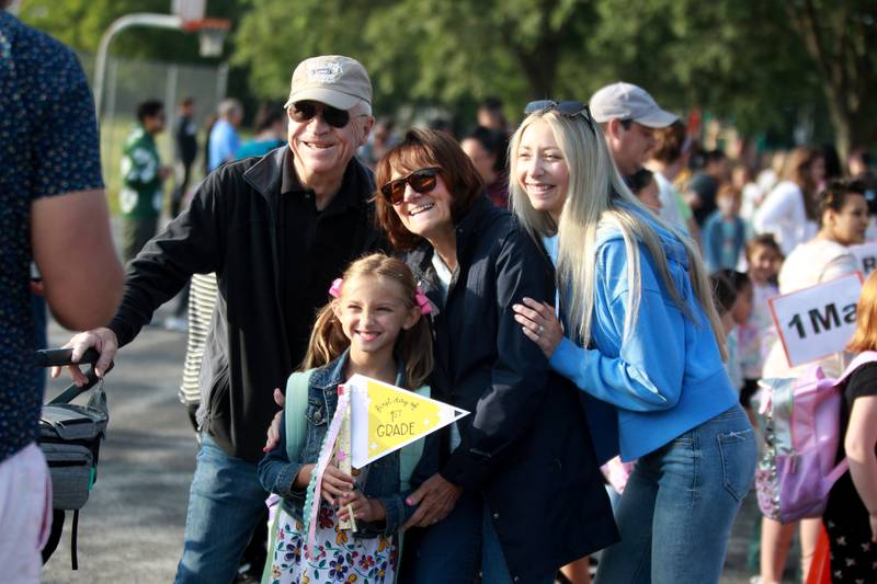 First-grader Hannah Thomas is surrounded by her grandparents, Greg and Kathy Frister, and her mom, Jill, as they pose for a photo on the first day of school Thursday, Aug. 22, 2024 at Harrison Street Elementary School in Geneva.