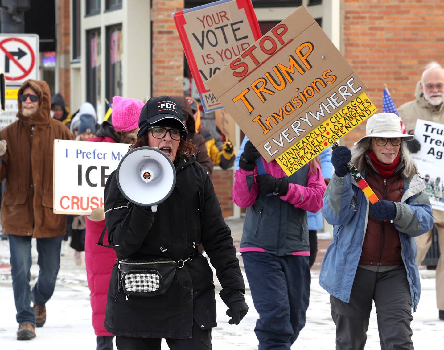Anna Wilhelmi, head of the DeKalb County Democratic Party, leads the chants as protesters march west down the sidewalk on Lincoln Highway in DeKalb Tuesday, Jan. 20, 2026, as part of a larger national Free America Walkout. The group is protesting what they perceive as an escalating fascist threat under President Donald Trump and his administration.