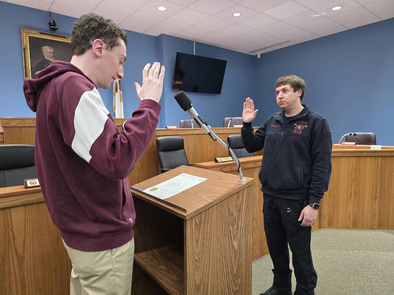 Kyle Camatti (right) takes the oath to become a full-time La Salle firefighter from the city's deputy clerk Brent Bader on Thursday, Feb. 27, 2024, at City Hall.