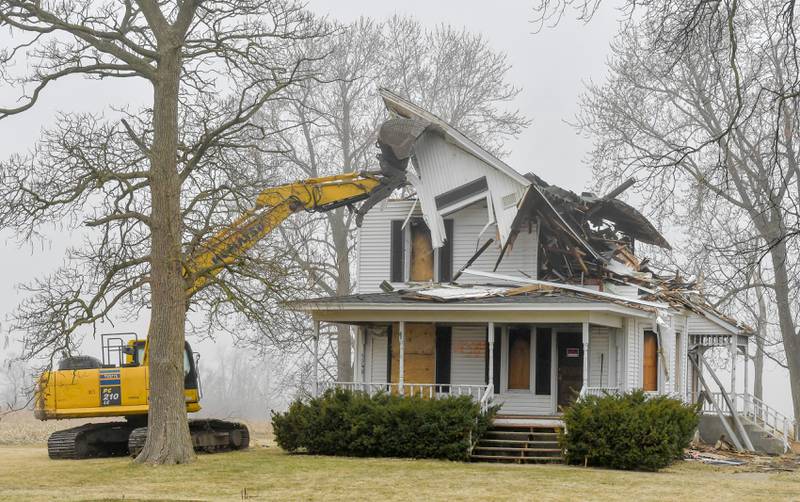The roof of Peck farm house at 64 Peck Road in Geneva is toppled during the demolition on Wednesday, March 22, 2023.