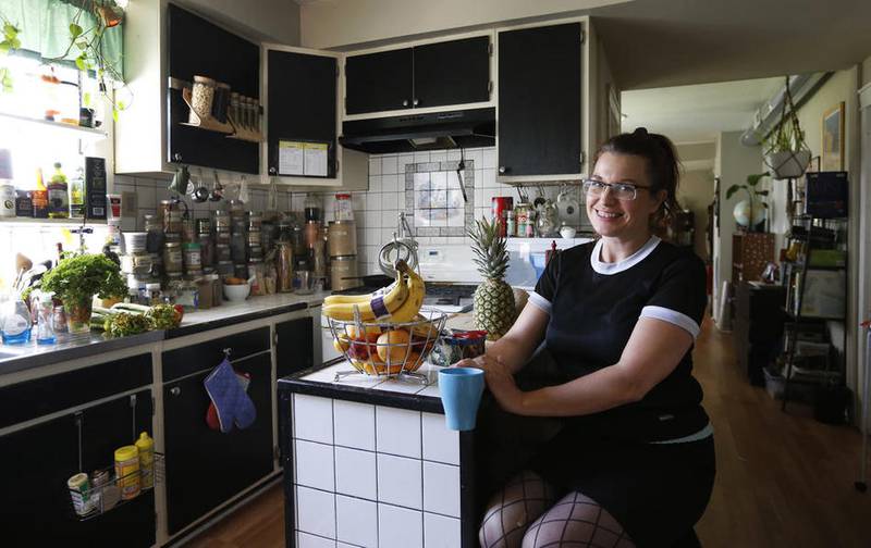 In this photo taken Friday, June 17, 2016, Laura Schofield poses for a portrait in her Chicago home where she offers up a bedroom for Airbnb travelers. Schofield, a mother of four in the city's Humboldt Park neighborhood, said renting a room in her home for around $50 a night helps her make ends meet after a divorce.