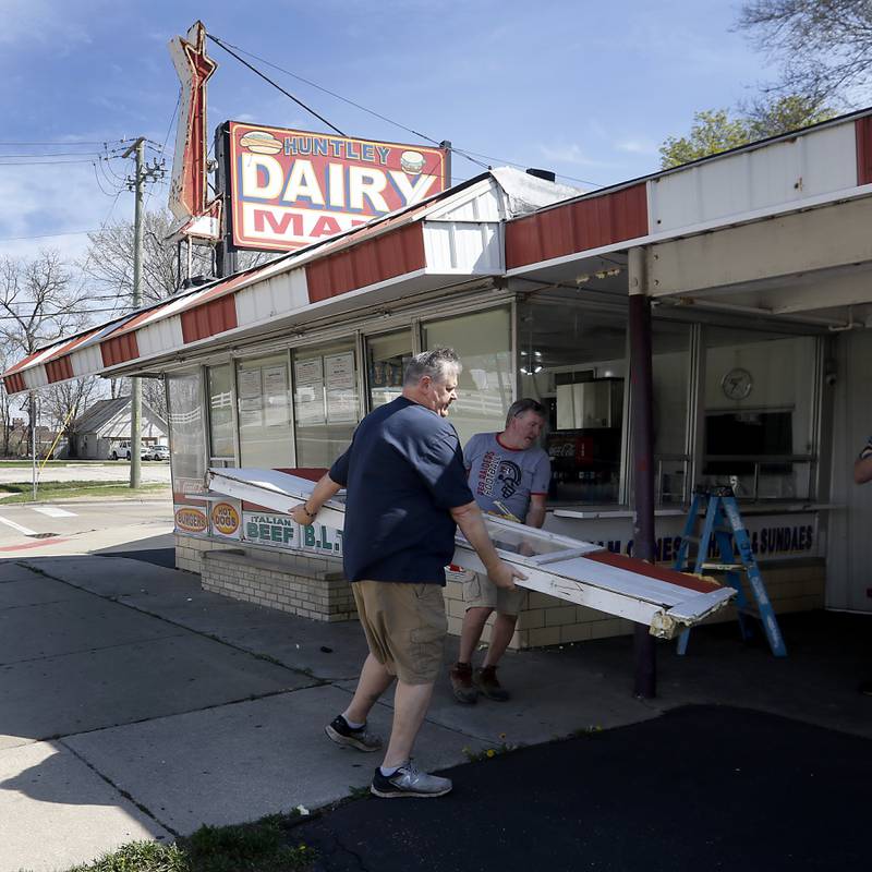 Bill Dunn, who recently purchased the Huntley Dairy Mart on Route 47 in Huntley, works with John Wean to remove the last winter panel from around the restaurant on Friday, April 14, 2023, as they prepare to reopen the Dairy Mart after it closed in February.