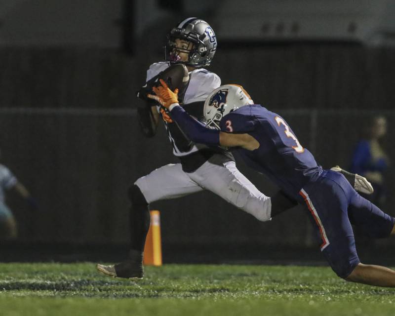 Oswego East's Donavin Eason (16) comes down with a long touchdown reception off of a scramble by Nicko Villacci (5) during football game between Oswego East at Oswego Friday, Oct 17, 2025 in Oswego.