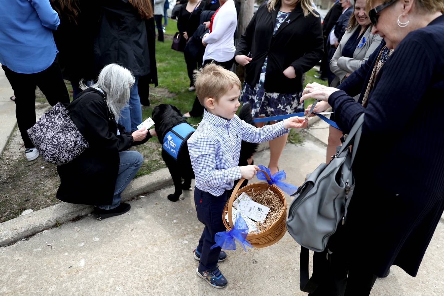 Liam Gay, 5, hands out flower seeds before a dedication in honor of his mom, Debra Bree, at the Kane County Child Advocacy Center in Geneva on Friday, April 29, 2022. Bree, who was the executive director of the Kane County Child Advocacy Center, died Aug. 27, 2020 of colon cancer.