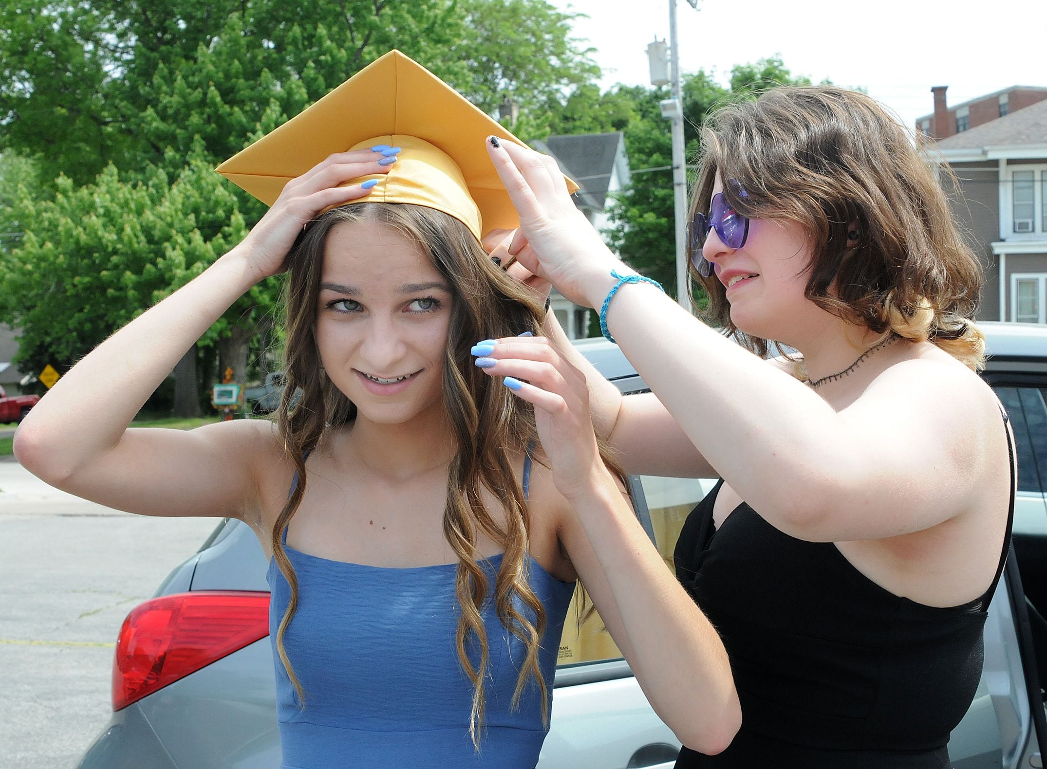 Mia Marabella helps Nell Stawiarski with her graduation cap prior to the ceremony Sunday, May 28, 2023, at Gould Stadium.