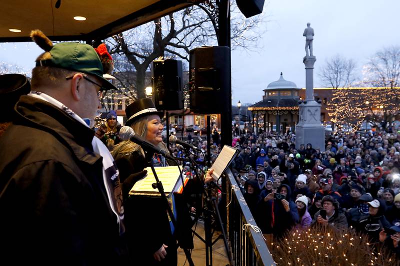Groundhog Days Committee members Rick Bellairs and Melissa McMahon speaks to the crowd Friday, Feb. 2, 2024, during the annual Groundhog Day Prognostication on the Woodstock Square.