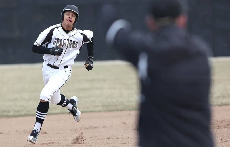 Sycamore's Tommy Townsend hustles to third as head coach Jason Cavanaugh gives him the stop sign during their game against Burlington Central Tuesday, March 21, 2023, at Sycamore Community Park.