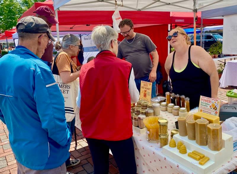 Customers chat with vendor Marie's Bees at the opening day of the DeKalb farmers market on Thursday, June 5, 2025, in Van Buer Plaza in downtown DeKalb. The market opened its 30th year Thursday.