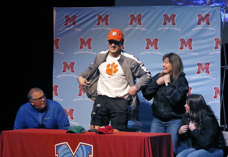 Christian Bentancur, flanked by his father, Patrick, mother, Elizabeth, and sister Angelica, shows his Clemson shirt as he announces Friday, Jan. 13, 2023, that he will attend Clemson University to play Division I football, at Marian Central High School. Bentancur, a highly recruited tight-end, narrowed his section down to Clemson from his final three colleges. The other two colleges were Ohio State and Oregon universities.