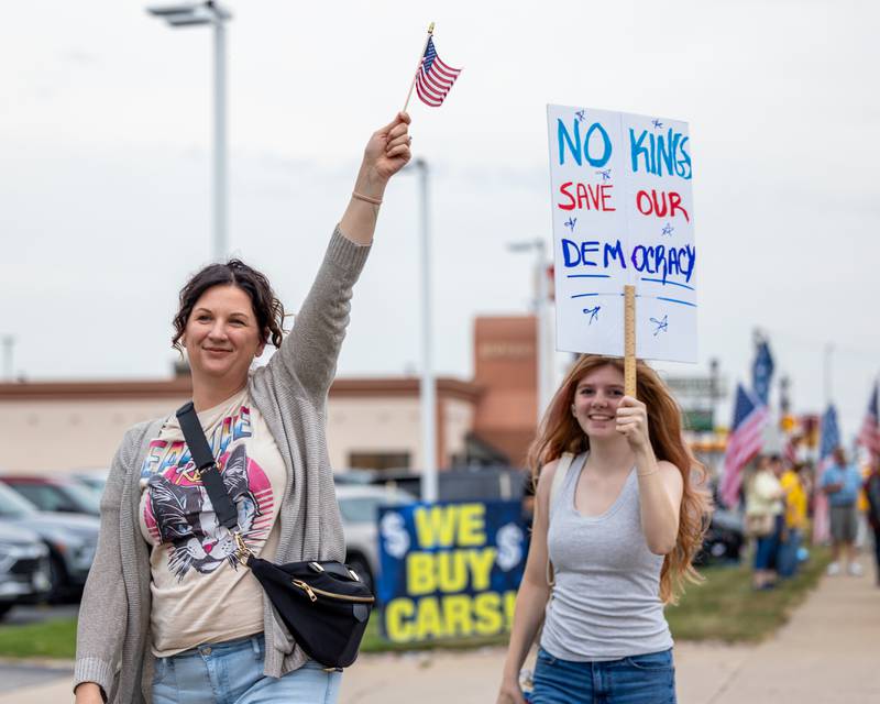 Protesters march down sidewalk at the ‘No Kings 2.0’ Protest on Saturday, October 18, 2025 on North Division Street in Morris.