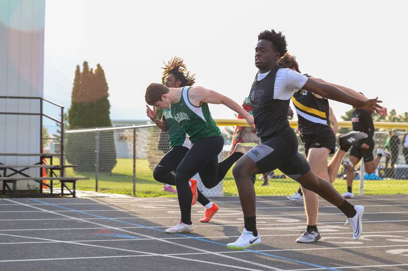 Kankakee's Jamari Anderson, right, narrowly crosses the finish line ahead of Bishop McNamara's Rhys Landsmann, second from left, during the third heat of the 100-meter dash at the Herscher Track Invite on Friday, May 1, 2026.