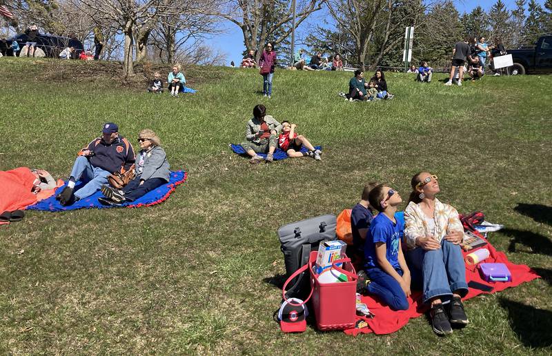 People gather at the Crystal Lake Park District's Nature Center to watch the partial eclipse Monday, April 8, 2024.