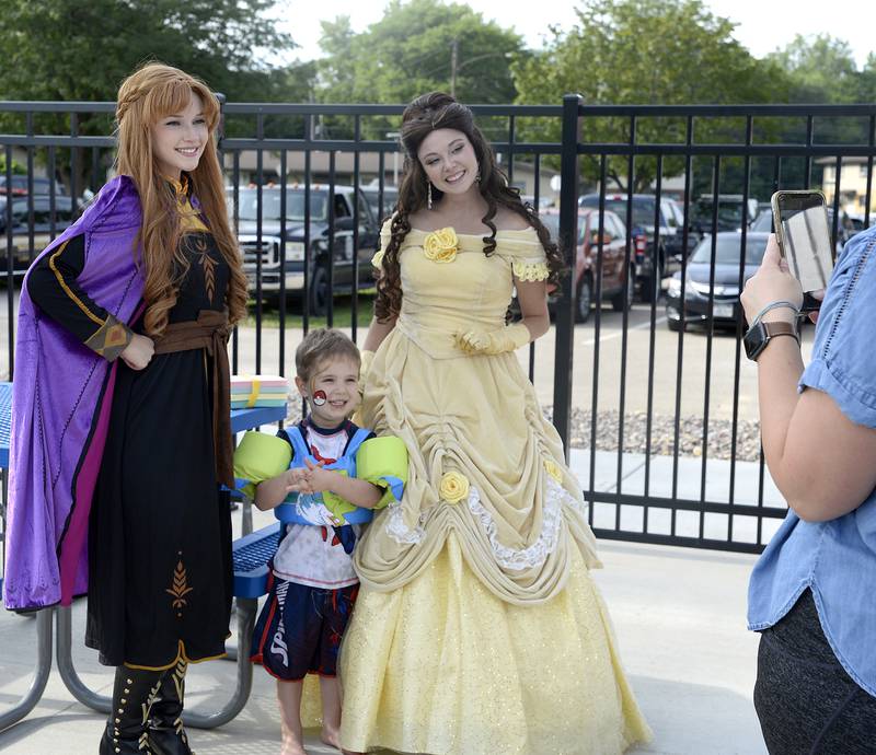 Barrett Brozman gets his picture taken Tuesday, Aug. 1, 2023, with Ann from "Frozen" and Belle from "Beauty and The Beast" at Ottawa’s Riordan Pool during National Night Out.