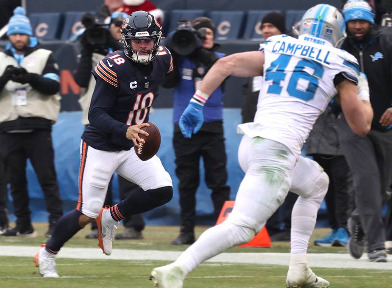 Chicago Bears quarterback Caleb Williams scrambles for yardage as Detroit Lions linebacker Jack Campbell looks to make the tackle during their game Sunday, Dec. 22, 2024, at Soldier Field in Chicago.