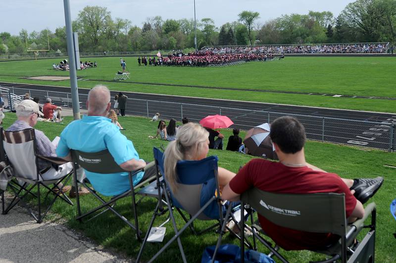 People watch from the hillside Saturday, May 14, 2022, during the graduation ceremony at Prairie Ridge High School.