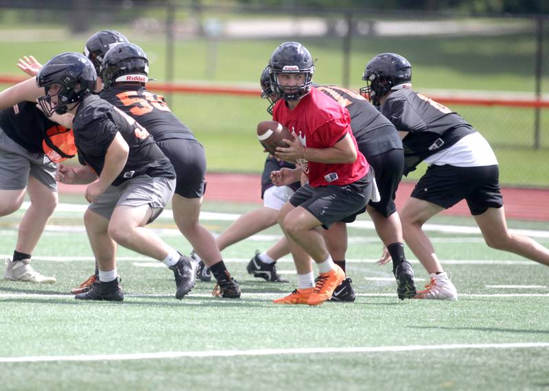 St. Charles East’s Mac Paul (center) plays quarterback during the first day of practice for the fall season on Monday, Aug. 7, 2023 at the school.