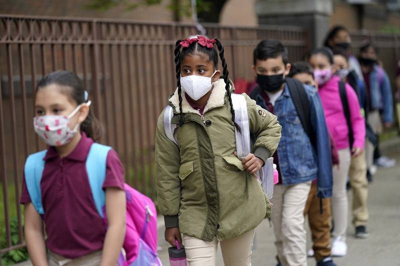 FILE - Students line up to enter Christa McAuliffe School in Jersey City, N.J., April 29, 2021. New Jersey Gov. Phil Murphy will end a statewide mask mandate to protect against COVID-19 in schools and child care centers, his office said Monday, Feb 7, 2022. (AP Photo/Seth Wenig, File)