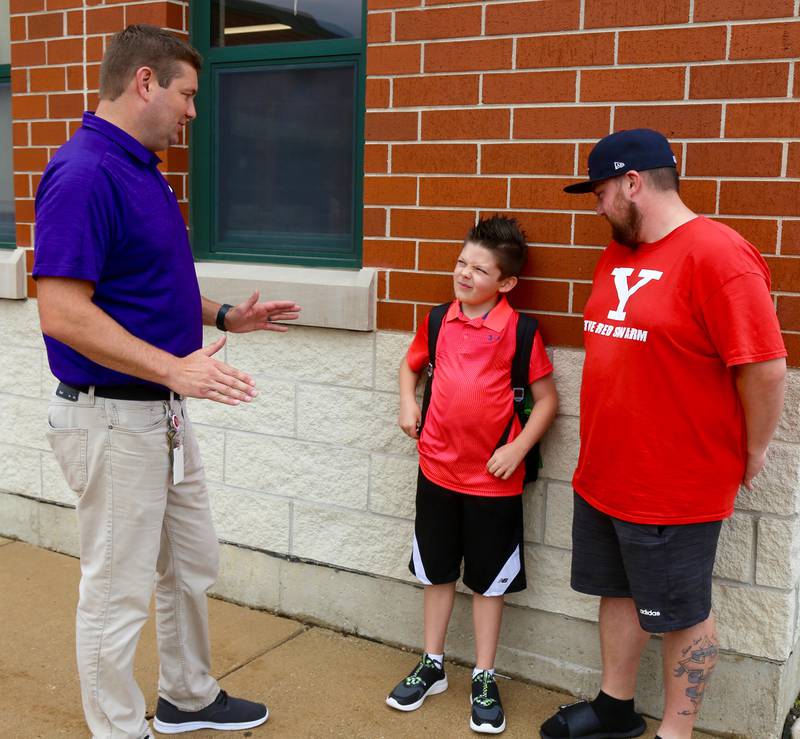 Principal Luke Baughman talks to fourth-grader Conley Staton and his dad, Ty Staton, on the first day of school at Emily G. Johns School in Plano on Thursday, Aug. 17, 2023.