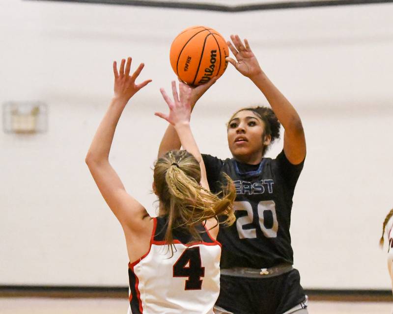 Oswego East's Jaliyah Shepard (20) takes a shot while being defended by Yorkville's Macie Jones (4) during the game on. Thursday Dec. 18, 2025, held at Yorkville High School.