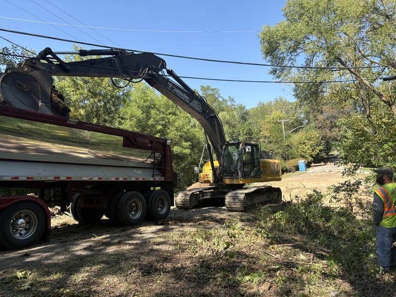 An excavator drops dirt into a dump truck at the Kelly Street Bridge project on Monday, Sept. 15, 2025.