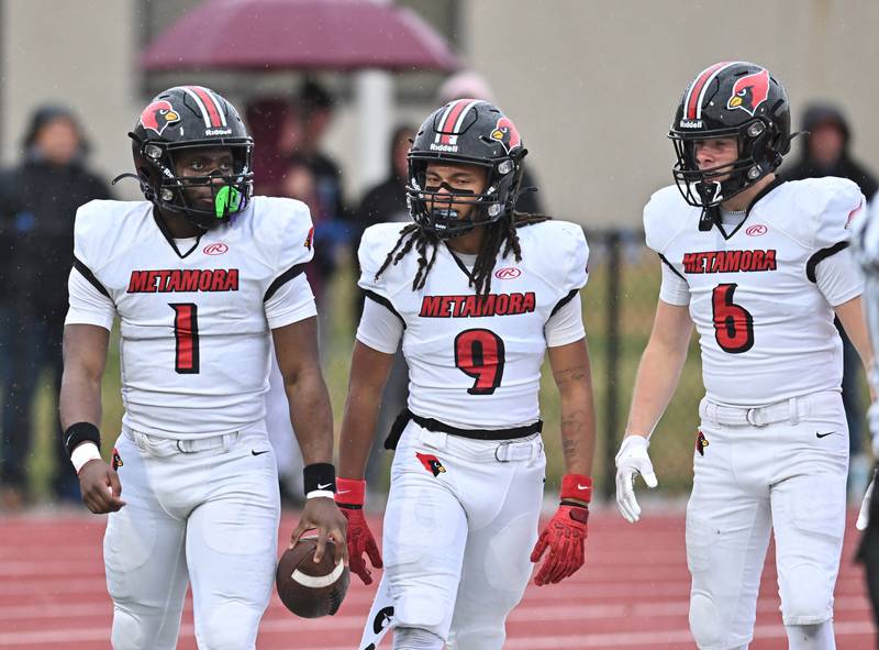 Metamora's Jaiduan Cranford (1) celebrate with Charlie Delinski (9) and Breydon Cox (6) after scoring a touchdown on the opening kickoff during the class 4A second round playoff game against Morris on Saturday, NOV. 08, 2025, at Morris.
