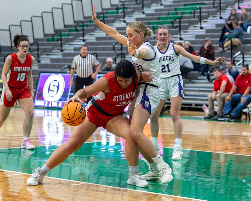 Alexis Thomas (21) of Streator dribbles ball and pushes into Emily Hoffman (1) of Serena on Monday, November 17, 2025 at Seneca High School in Seneca.