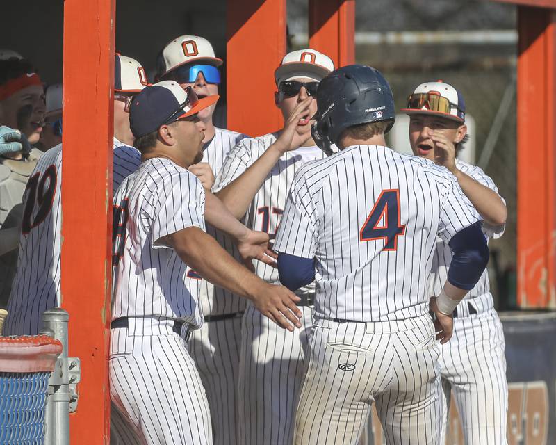 Oswego's Drew Kleinhans (4) is welcomed to the dug out by team mates after scoring during baseball game Oswego East at Oswego.  May 14, 2026 in Oswego.