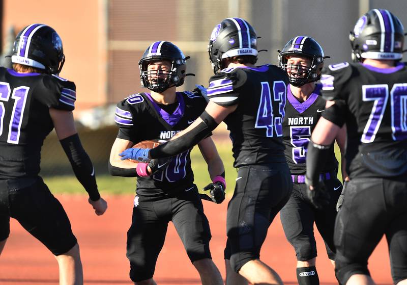 Downers Grove North's Oliver Thulin (10) celebrates with teammates after scoring the game's first touchdown during an IHSA Class 7A semifinal game against Normal Community on Nov. 18, 2023 at Downers Grove North High School in Downers Grove.