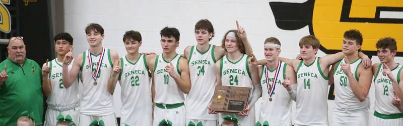 Members of the Seneca boys basketball team pose with the Tri-County Conference championship plaque after defeating Marquette on Friday, Jan. 31, 2025 at Putnam County High School.