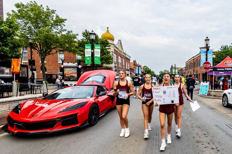 Members of Plainfield North's Cheer Team, Alannah Cosgrove, Bay Miller, Olivia VanTilburg, and Heidi Turner, sell 50/50 raffle tickets to help support next year's program during Plainfield Cruise Night on June 3, 2025.