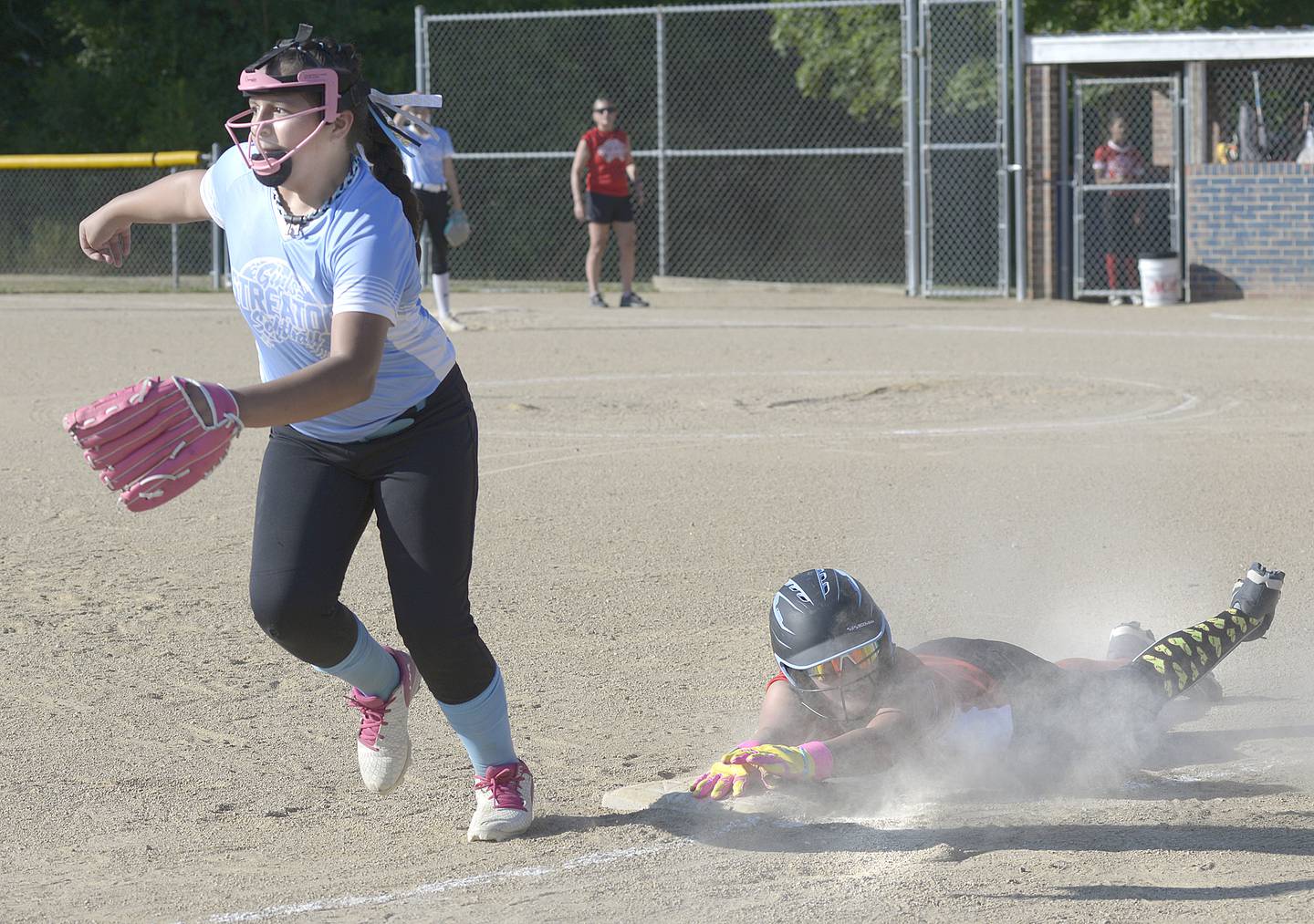 Dairy Queen's Makenna Davies dives back into third base as Streator MJ Track Works Sophia Gonzalez chases a throw during Wednesday's Streator Girls Softball 14U city title game at Bodznick Park in Streator.