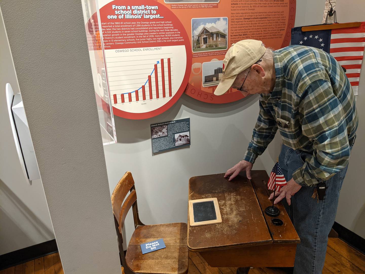 Little White School Museum volunteer director Roger Matile looks at a student desk from a one-room school called Church School, which he attended.
