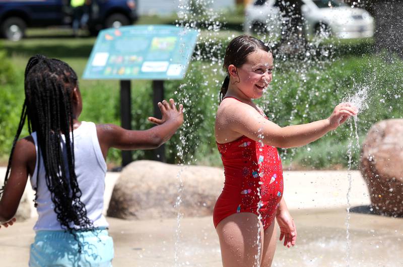Visitors enjoy the water fountains Tuesday, June 24, 2025, on the splash pad at Welsh Park in DeKalb.