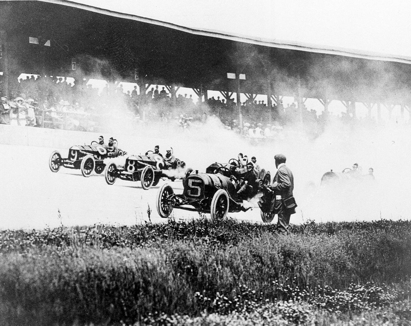 In this May 30, 1911, file photo, drivers Will Jones (9), Joe Jagersberger (8) and Louis Disbrow (5) race with their riding mechanics in the first Indianapolis 500 auto race at Indianapolis Motor Speedway in Indianapolis, Ind.
