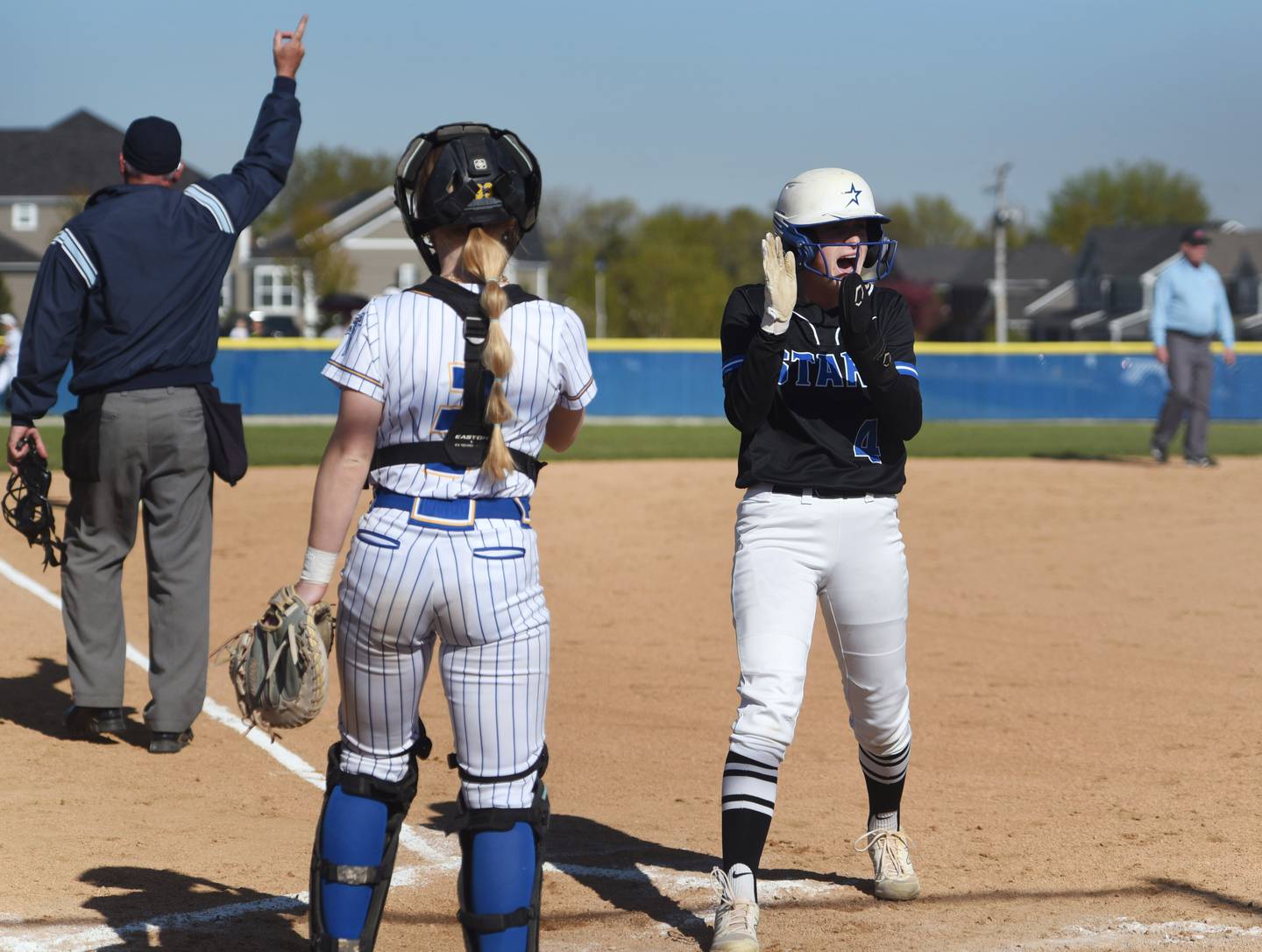 St. Charles North's Julia Larson (4) celebrates scoring after teammate Maddie Hernandez hit a home run during Wednesday’s softball game in Wheaton.