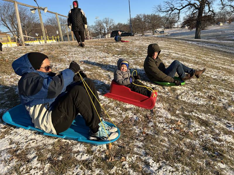 Juan Orellana and his son, Josiah, 3, of Naples, Florida, and Sam Schouten of Morrison, sled down the hill at Winter Park in Morrison on Friday, Jan. 3, 2025. Josiah and Juan and their family were visiting relatives in Morrison and wanted to try sledding following the dusting of snow that fell across the region.