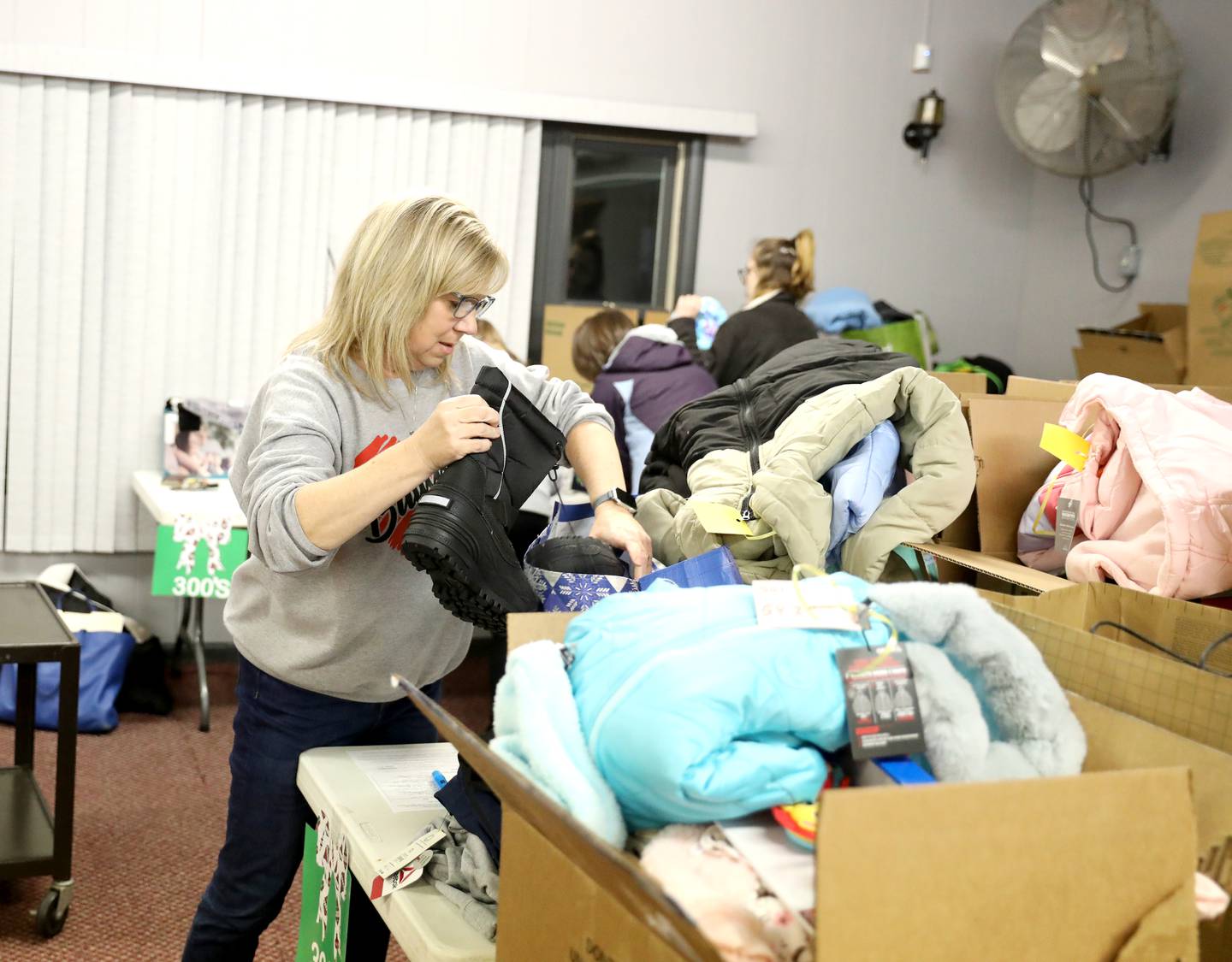 Volunteer Peggy Skupa adds winter essentials to a donation box as part of the Batavia United Way Adopt-A-Family program.