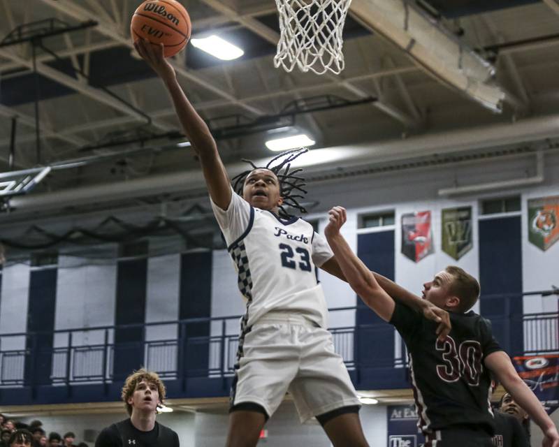 Oswego East's Mason Lockett IV (23) puts in a layup during their basketball game between Plainfield North at Oswego East Friday, Dec 5, 2025 in Oswego.