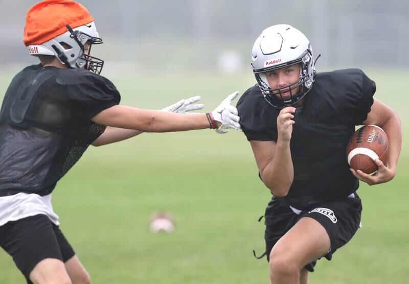 Kaneland quarterback Troyer Carlson carries the ball during practice Wednesday, Aug. 9, 2023, at the school in Maple Park.